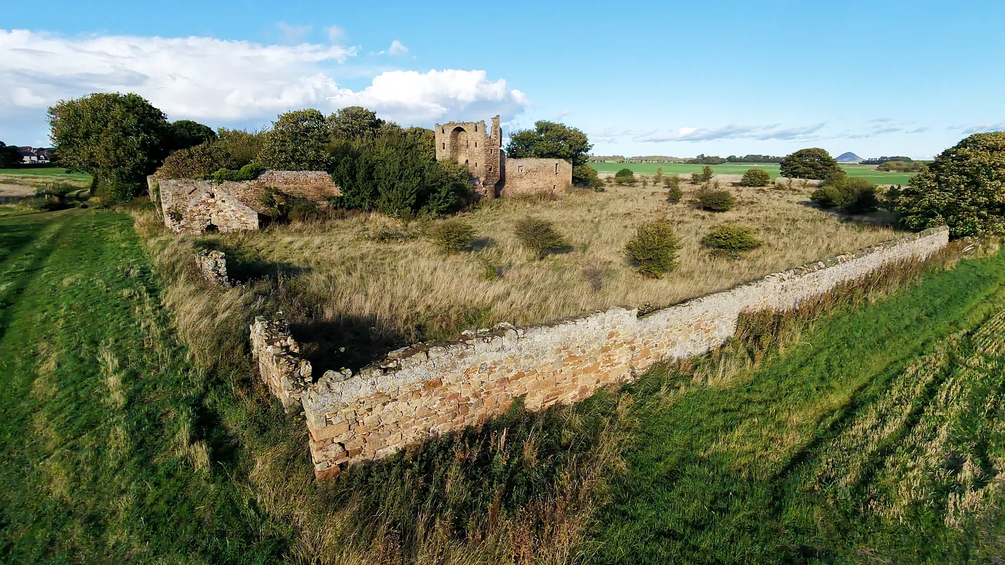 Perimeter wall of Saltcoats Castle among fields